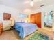 Bedroom features a double bed, a large closet, and colorful art at 2907 W Euclid Ave, Tampa, FL 33629