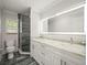 Bright bathroom featuring a modern double vanity, framed mirror, and tiled walk-in shower at 3663 Berger Rd, Lutz, FL 33548