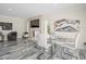 Bright dining area with glass table and white chairs, adjacent to a fireplace and fish tank at 3663 Berger Rd, Lutz, FL 33548