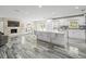 Modern kitchen with white cabinetry, stainless steel appliances, marble countertops, and large marbled floors at 3663 Berger Rd, Lutz, FL 33548