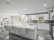 White kitchen with marble countertops, large island, and recessed lighting at 3663 Berger Rd, Lutz, FL 33548