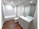 Updated bathroom with a bathtub, toilet and grey vanity at 3749 Loury Dr, Wesley Chapel, FL 33543