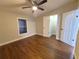 Well-lit bedroom with ceiling fan and dark brown laminate flooring at 3749 Loury Dr, Wesley Chapel, FL 33543