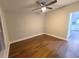 Bright bedroom with ceiling fan and dark brown laminate flooring at 3749 Loury Dr, Wesley Chapel, FL 33543