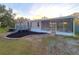 A beige manufactured home with a gray deck, landscaping, and screened porch at 3749 Loury Dr, Wesley Chapel, FL 33543