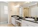 Double vanity bathroom with granite countertops and a large mirror at 3814 W Sevilla St, Tampa, FL 33629