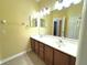 Double vanity bathroom with a large mirror and tile flooring at 4110 Huntingdale Ct, Wesley Chapel, FL 33543