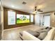 Cozy living room featuring a comfortable sofa, ceiling fan, and a view of the property on the TV screen at 4110 Huntingdale Ct, Wesley Chapel, FL 33543