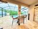 Covered outdoor kitchen area with a stainless steel grill, bar seating, and access to the screened pool at 4110 Huntingdale Ct, Wesley Chapel, FL 33543