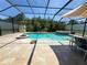 A beautiful screened-in pool with integrated spa and a table set for outdoor entertaining at 4110 Huntingdale Ct, Wesley Chapel, FL 33543