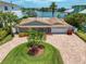 Aerial view of waterfront home with circular driveway, landscaping, and private dock at 476 Harbor S Dr, Indian Rocks Beach, FL 33785