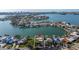 Aerial view of waterfront home with lush greenery and a private boat dock in a coastal community at 521 Harbor N Dr, Indian Rocks Beach, FL 33785