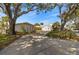 A long driveway leads to charming white homes with mature trees providing shade and curb appeal at 521 Harbor N Dr, Indian Rocks Beach, FL 33785