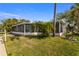 Exterior view of the screened porch with tropical plants, offering an enjoyable outdoor space at 521 Harbor N Dr, Indian Rocks Beach, FL 33785