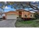 Attractive single-story home with a terracotta roof, landscaping, and a paved driveway at 5232 White Sand Ne Cir, St Petersburg, FL 33703