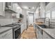 Updated kitchen featuring stainless steel sink and range, white cabinets, and tile floor at 5232 White Sand Ne Cir, St Petersburg, FL 33703