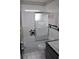 Bathroom featuring swan design shower door, white tile, and dark accents at 5353 Shaw St, New Port Richey, FL 34652