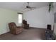 Bright living room featuring a ceiling fan, neutral carpeting, and plenty of space at 5353 Shaw St, New Port Richey, FL 34652