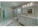 Modern bathroom with white vanity, marble floors, and glass shower at 659 Keene Rd, Largo, FL 33771