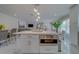 White kitchen with island, stainless steel appliances and marble floors at 659 Keene Rd, Largo, FL 33771