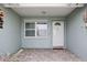 Inviting front porch with a white door, window, neutral tile flooring, and a marine-style door knocker at 6702 Harbor Dr, Hudson, FL 34667