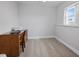 Minimalist office with a dark wood desk and chair by a window. Printer and shelves on the wall at 6702 Harbor Dr, Hudson, FL 34667