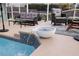 Close-up of pool with relaxing patio furniture, outdoor fountain, and tiled accents at 6702 Harbor Dr, Hudson, FL 34667