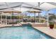 Screened-in pool area with comfortable seating, a waterfall feature, and a view of the waterway at 6702 Harbor Dr, Hudson, FL 34667