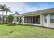 View of the backyard with a screened-in lanai and lush landscaping at 7408 Trovita Rd, Land O Lakes, FL 34637