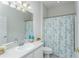 Clean bathroom with floral shower curtain, single vanity, and ample lighting, perfect for a guest bath at 7408 Trovita Rd, Land O Lakes, FL 34637