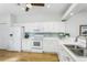 Well-lit kitchen with white cabinetry, stainless steel appliances, and backsplash tiles at 7408 Trovita Rd, Land O Lakes, FL 34637