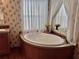 Relaxing bathroom with a corner soaking tub and a large window at 8326 Fantasia Park Way, Riverview, FL 33578