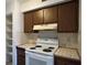 Kitchen with white appliances and wood cabinets at 9011 Westchester Cir # 24, Tampa, FL 33604