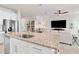 Open concept kitchen and living area with granite counter and large TV at 10023 Eventide Trl, Parrish, FL 34219