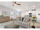 Bright living room features a comfy sofa and open concept kitchen at 10023 Eventide Trl, Parrish, FL 34219