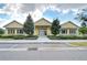 Community center with yellow exterior, landscaping, and parking at 11139 Winthrop Lake Dr, Riverview, FL 33578