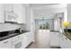 Modern kitchen with white cabinetry, dark countertops and stainless appliances open to living area at 12033 Gandy N Blvd # 145, St Petersburg, FL 33702