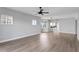 Open living area with wood-look floors, ceiling fan, and view into kitchen area at 12033 Gandy N Blvd # 145, St Petersburg, FL 33702