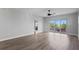 Expansive living space with sliding glass doors to the balcony, ceiling fan, and wood-look floors at 12033 Gandy N Blvd # 145, St Petersburg, FL 33702