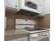 Kitchen with a cooktop, microwave, and overhead ventilation hood at 1235 S Highland Ave # 3-303, Clearwater, FL 33756