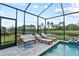 Screened pool area featuring patio furniture and lounge chairs overlooking serene water view at 14866 Paddock Pond Ave, Lithia, FL 33547