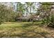 The expansive yard and screened-in porch provide a peaceful view of the surrounding trees and greenery at 170 Greenhaven Cir, Oldsmar, FL 34677