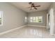 Bright bedroom with shuttered windows, tile flooring, and neutral paint at 170 Greenhaven Cir, Oldsmar, FL 34677