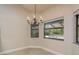 Cozy dining area with a decorative chandelier and views of the screened-in pool area at 170 Greenhaven Cir, Oldsmar, FL 34677