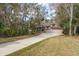 View of the front of the home and driveway surrounded by beautiful trees and lush landscaping at 170 Greenhaven Cir, Oldsmar, FL 34677