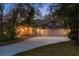 Inviting home exterior at dusk with warm lighting and a spacious driveway at 170 Greenhaven Cir, Oldsmar, FL 34677