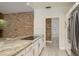 Bright kitchen features granite countertops, stainless appliances, and a stylish brick accent wall at 170 Greenhaven Cir, Oldsmar, FL 34677
