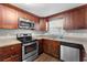 Kitchen features stainless steel appliances and wood cabinets at 2333 Tahitian Dr, Holiday, FL 34691