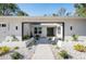 Modern home exterior with landscaped entryway and three-car garage at 2940 Hadleigh Ct, Clearwater, FL 33761