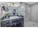 Modern bathroom with black vanity, glass block shower, and gray tile flooring at 314 33Rd Ne Ave, St Petersburg, FL 33704